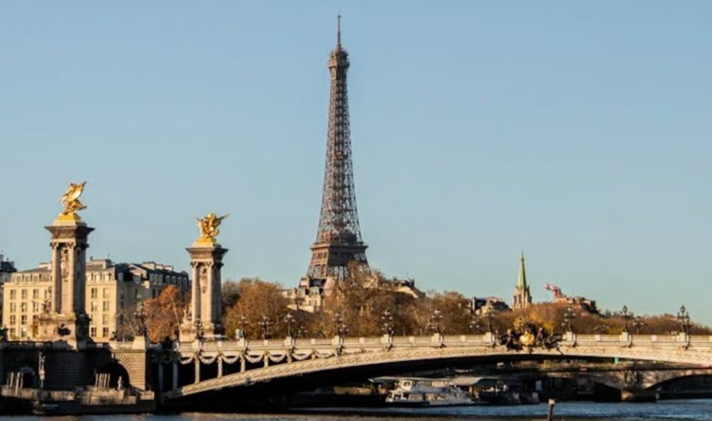Great cities to visit in Europe Scenic. View of Eiffel Tower from the Seine River with boats and Parisian architecture.