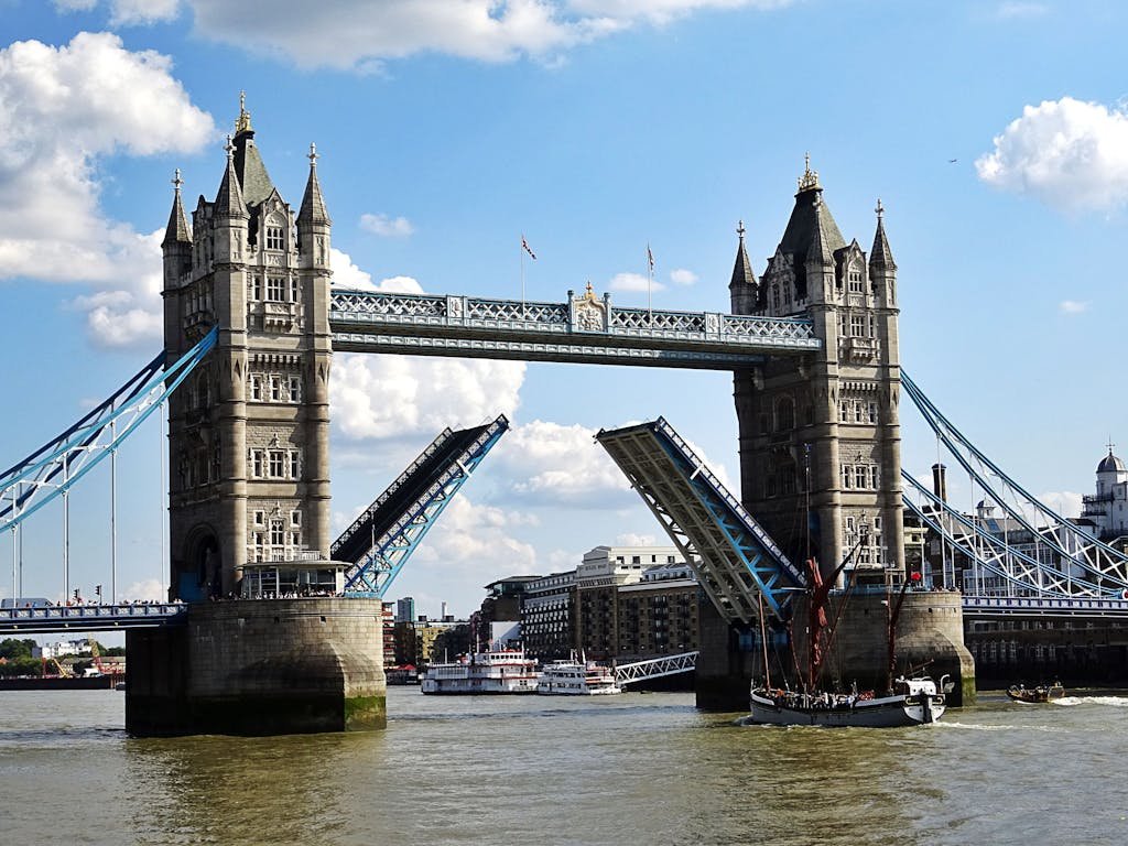 Iconic Tower Bridge in London with raised bascules over the River Thames on a sunny day.